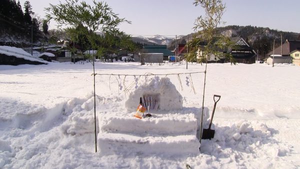 御神木の脇の雪の祭壇の写真