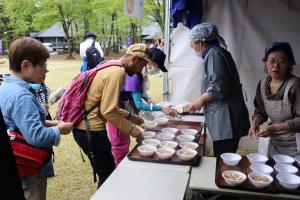 特産汁をふるまうスタッフ