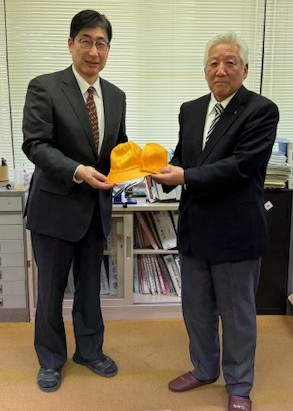 帽子を手に取る教育長と小林様